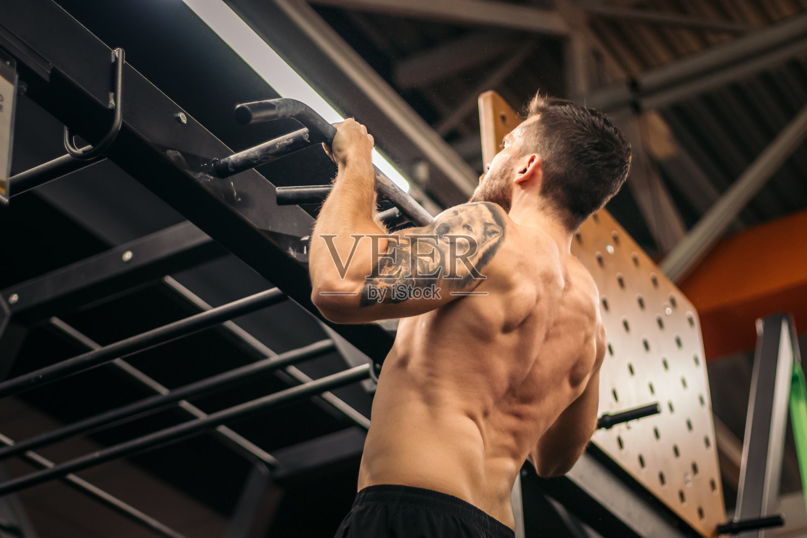 男运动员在健身房做引体向上照片摄影图片