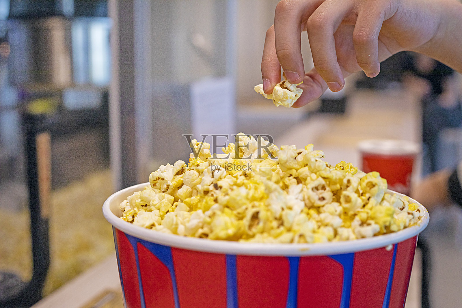 孩子在看电影前品尝经典的爆米花。家庭出游日照片摄影图片