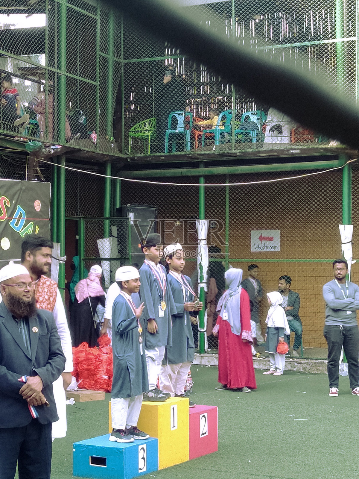 2024年7月2日，孟加拉国达卡。照片中，一群穿着传统印度服装、戴着头巾的小男孩站在舞台上，拿着奖杯和奖牌庆祝胜利。照片摄影图片