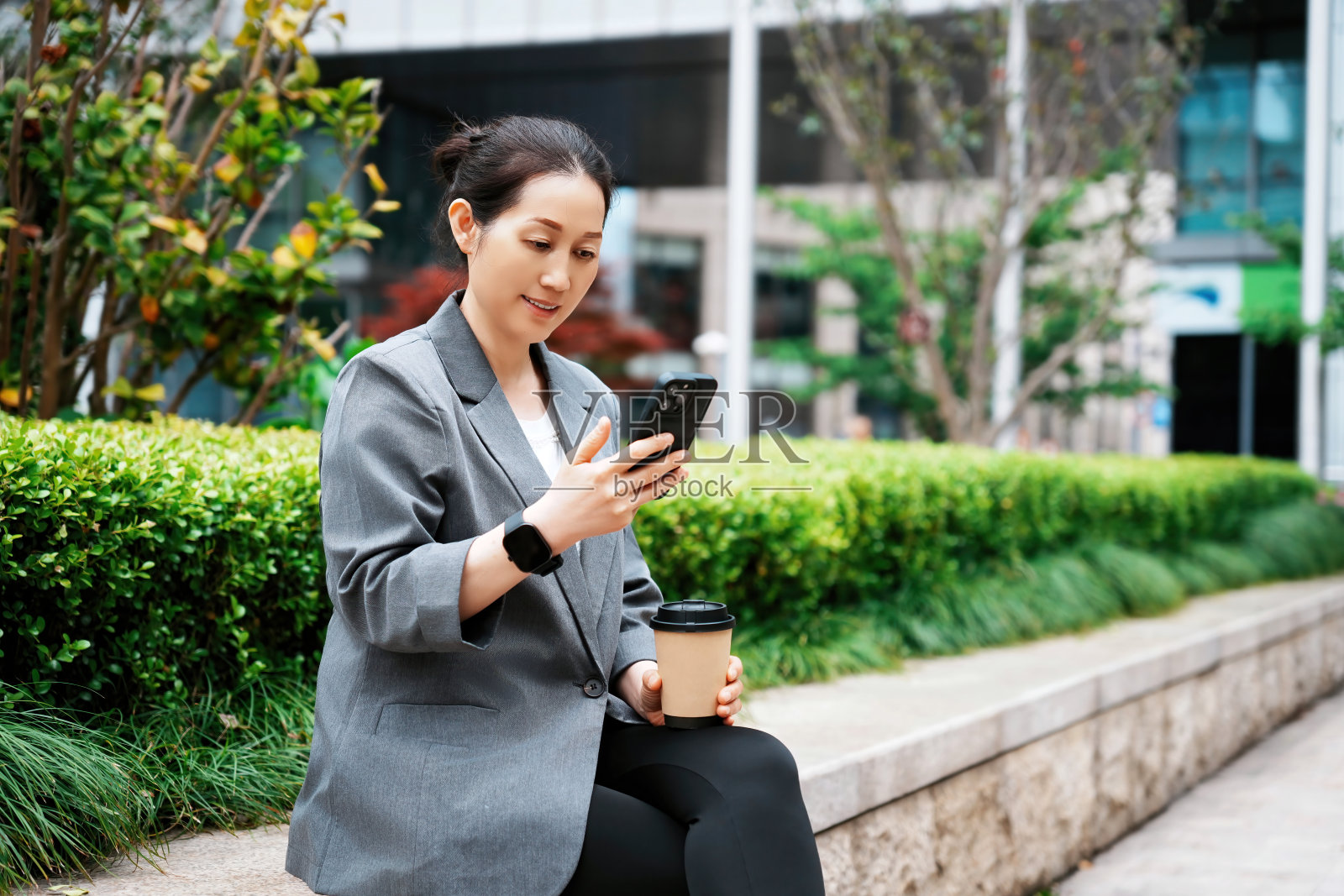 在户外享受咖啡和智能手机的女商人照片摄影图片