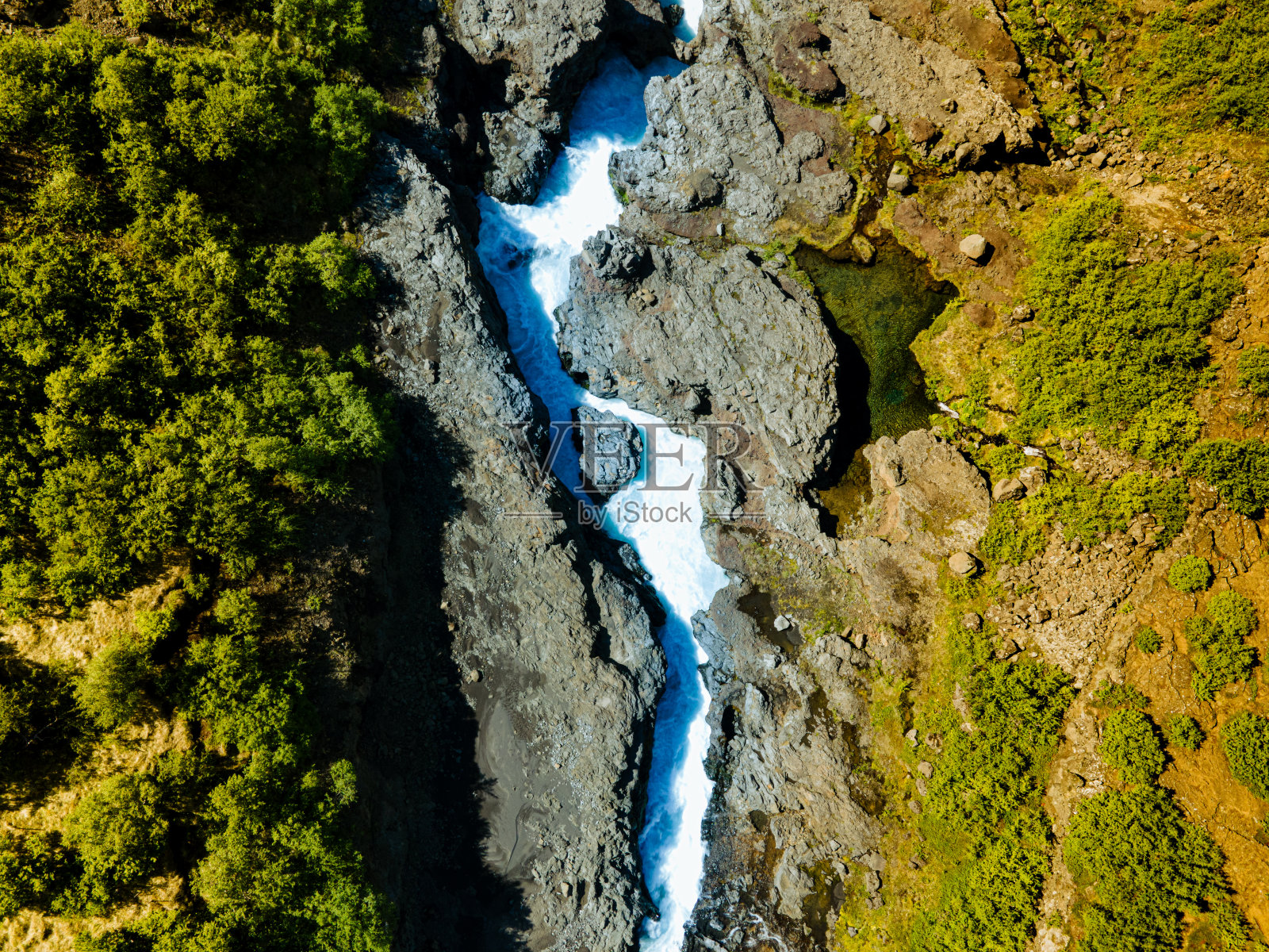 从空中俯瞰，蓝色的水在山间河流流过岩石峡谷照片摄影图片