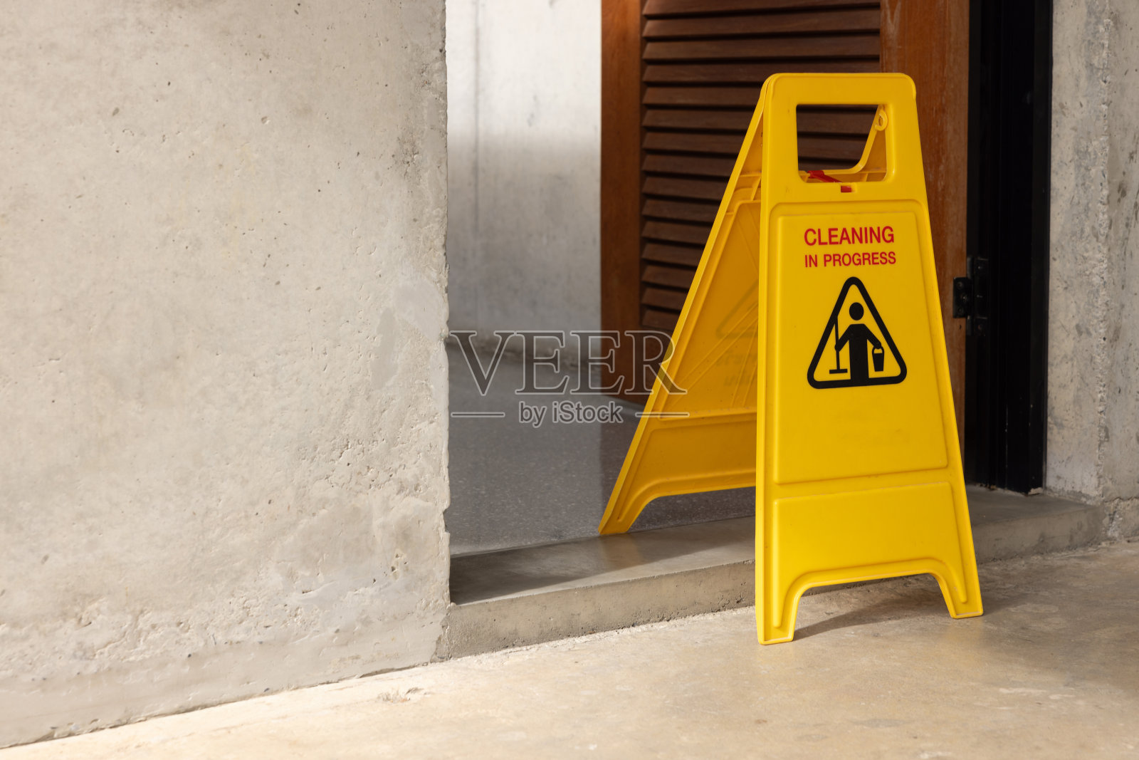 地上有一个黄色的牌子，上面有一个人和一个杯子照片摄影图片