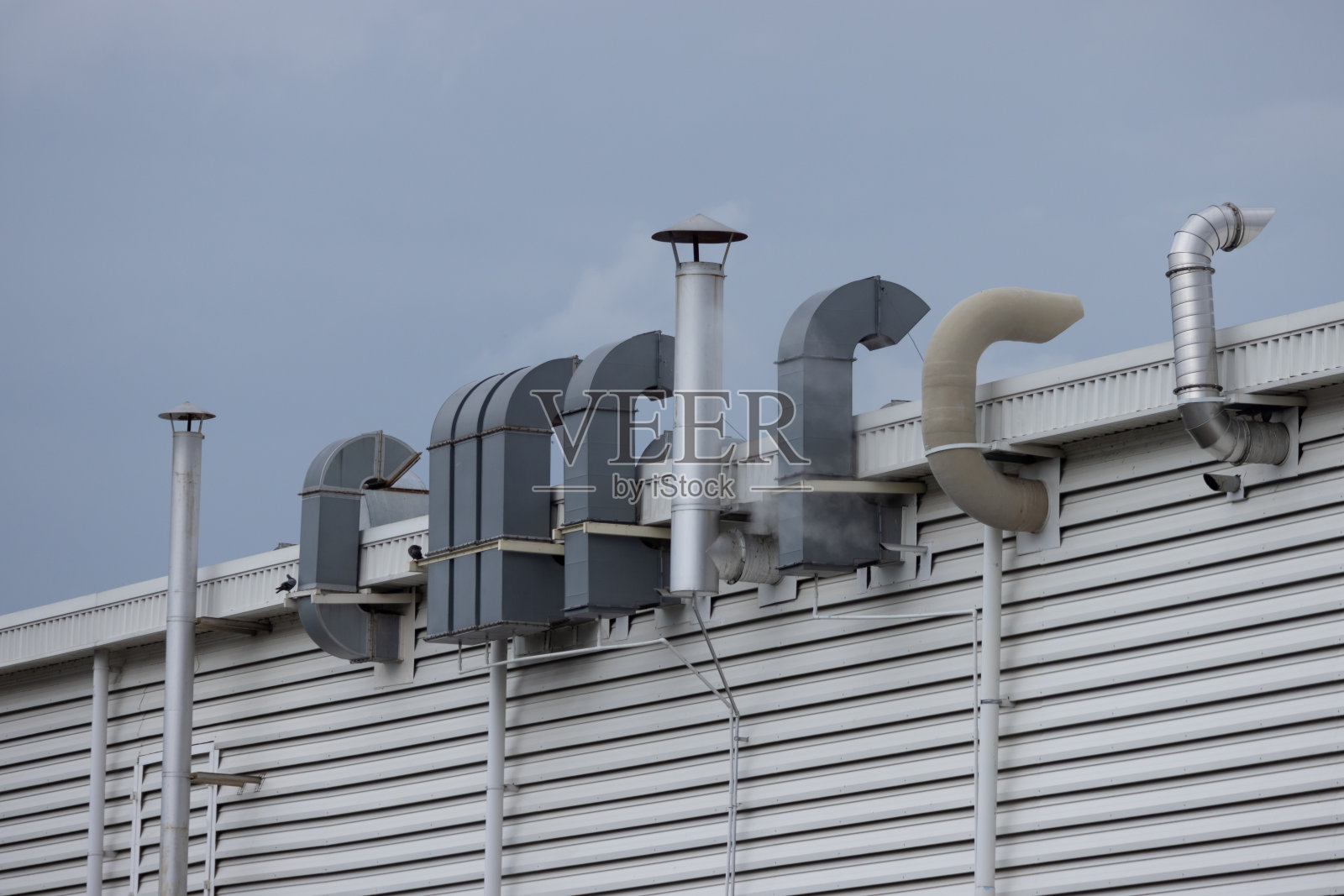 屋顶上有很多管道和通风口的建筑照片摄影图片