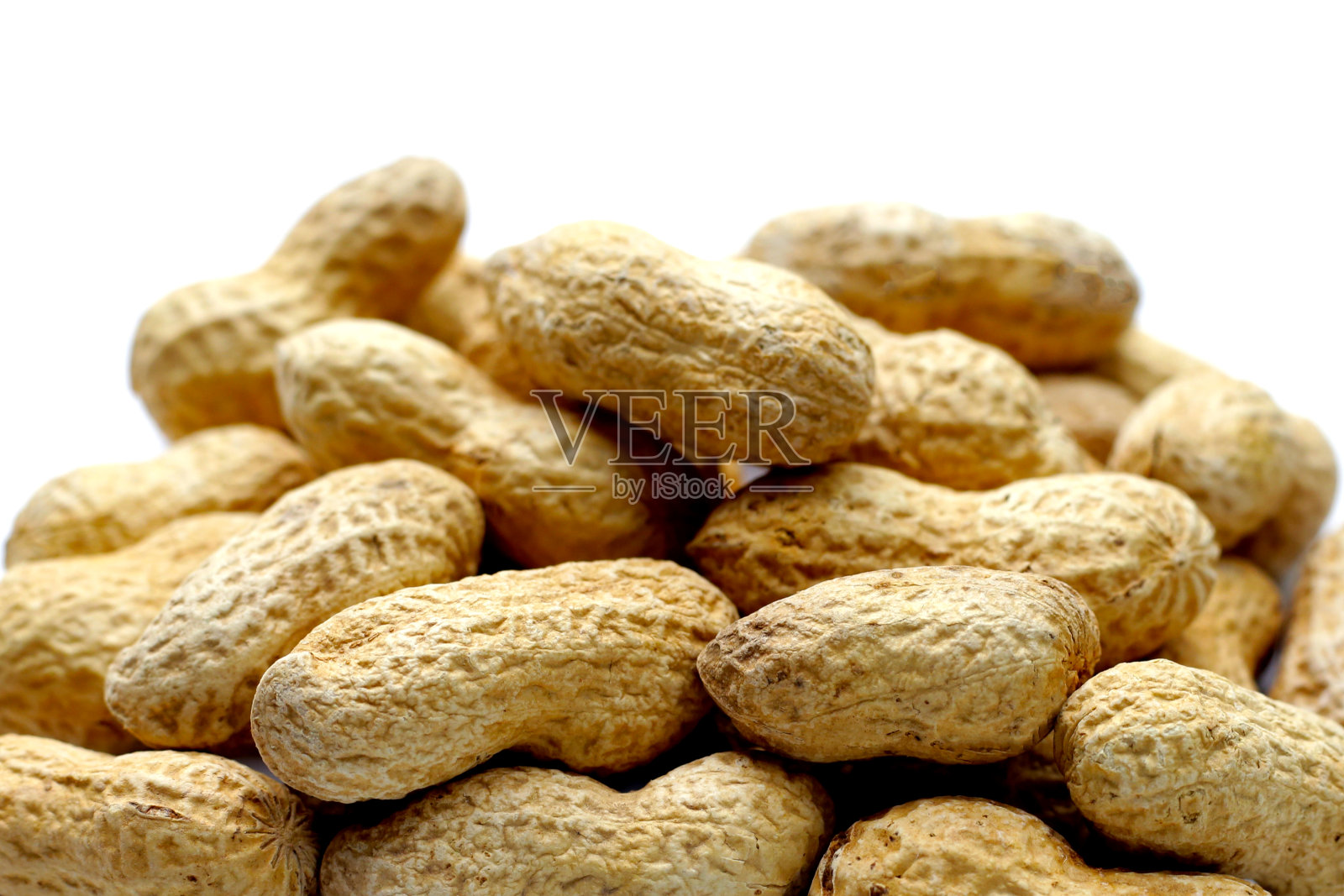 白底带壳烤花生。照片摄影图片