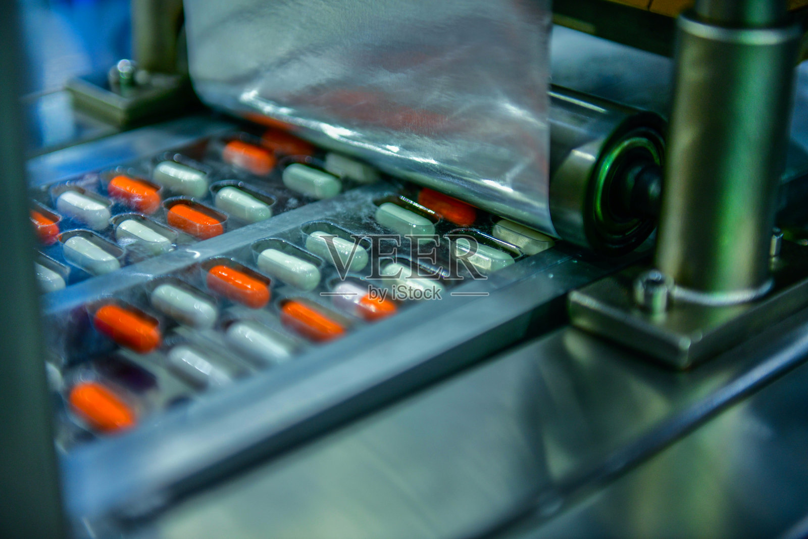 现代制药厂生产线及包装过程中的胶囊药物照片摄影图片