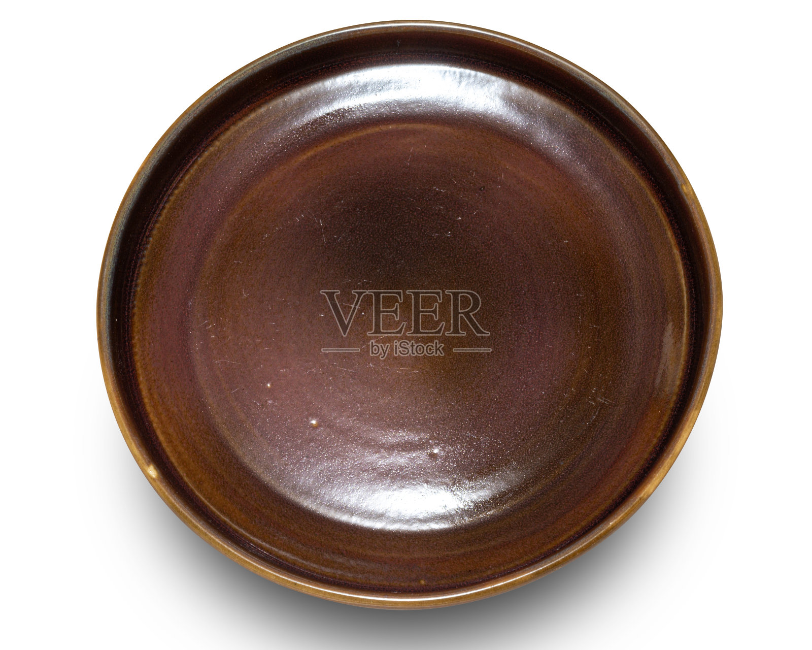 在白色背景上隔离的棕色圆形陶瓷板。照片摄影图片
