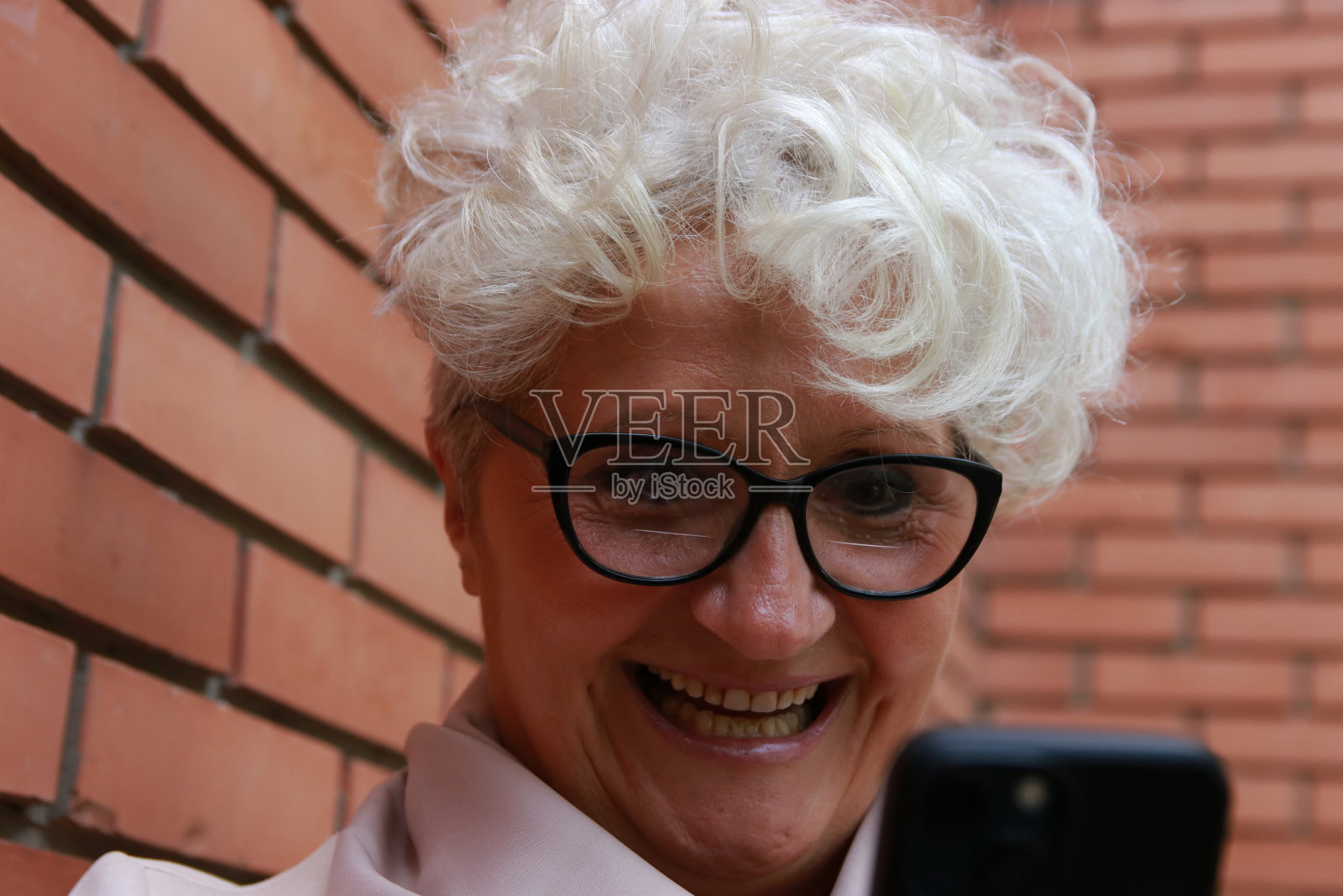 拿着智能手机的资深女性照片摄影图片