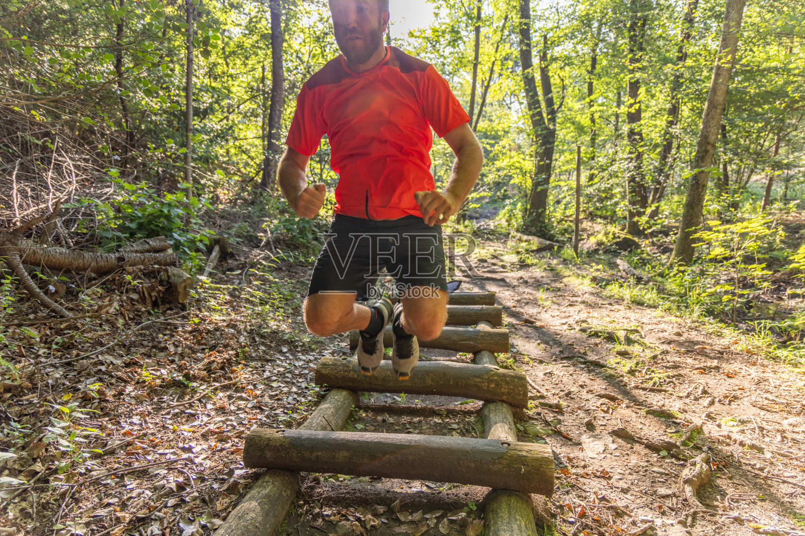 在森林小道上跳过原木的人照片摄影图片