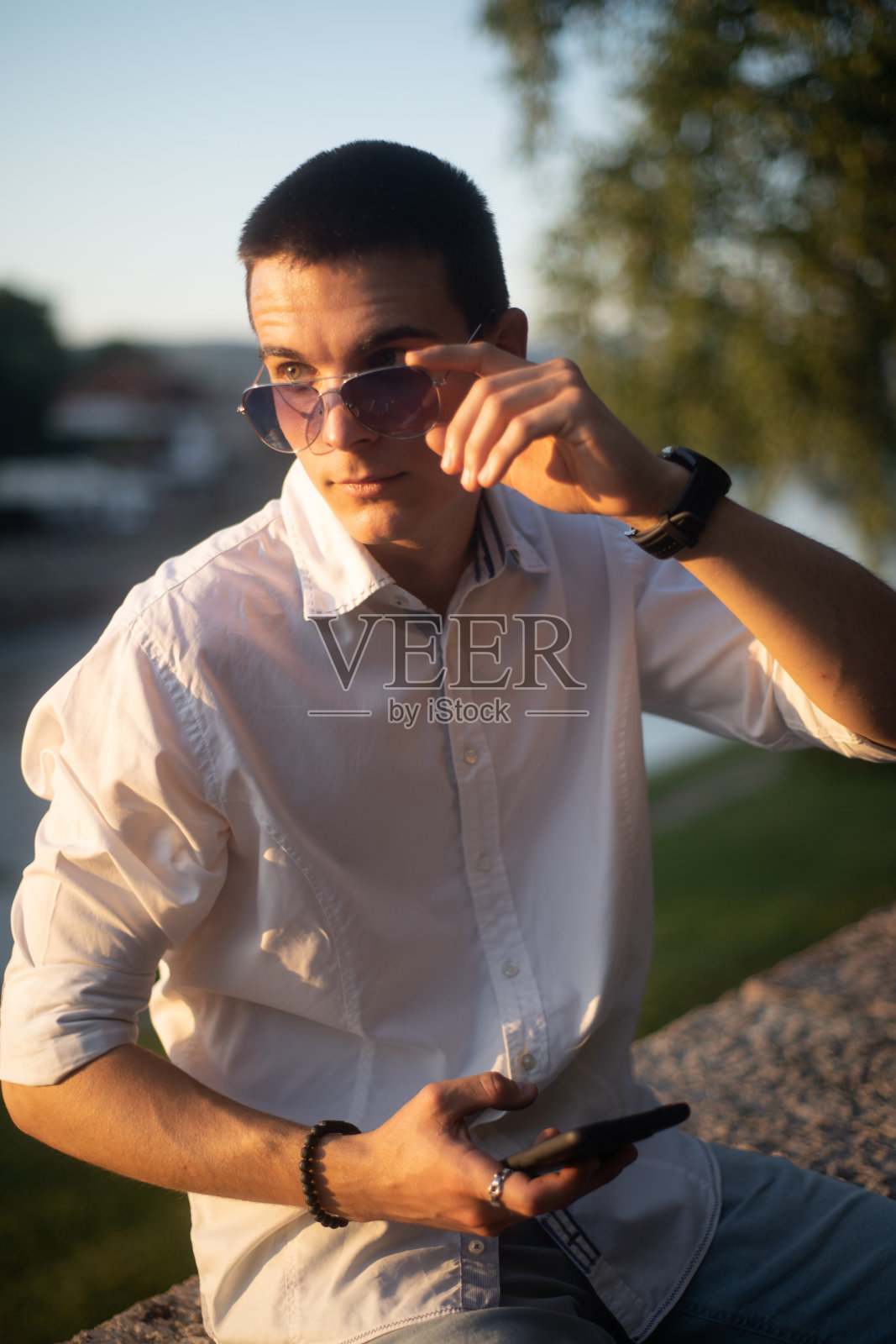 戴墨镜的年轻人在户外打电话照片摄影图片