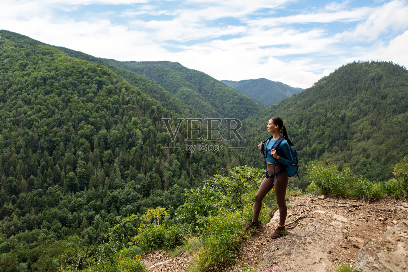 运动的女徒步旅行者与背包享受山的景色，呼吸新鲜的空气在夏天的一天，全身照片摄影图片