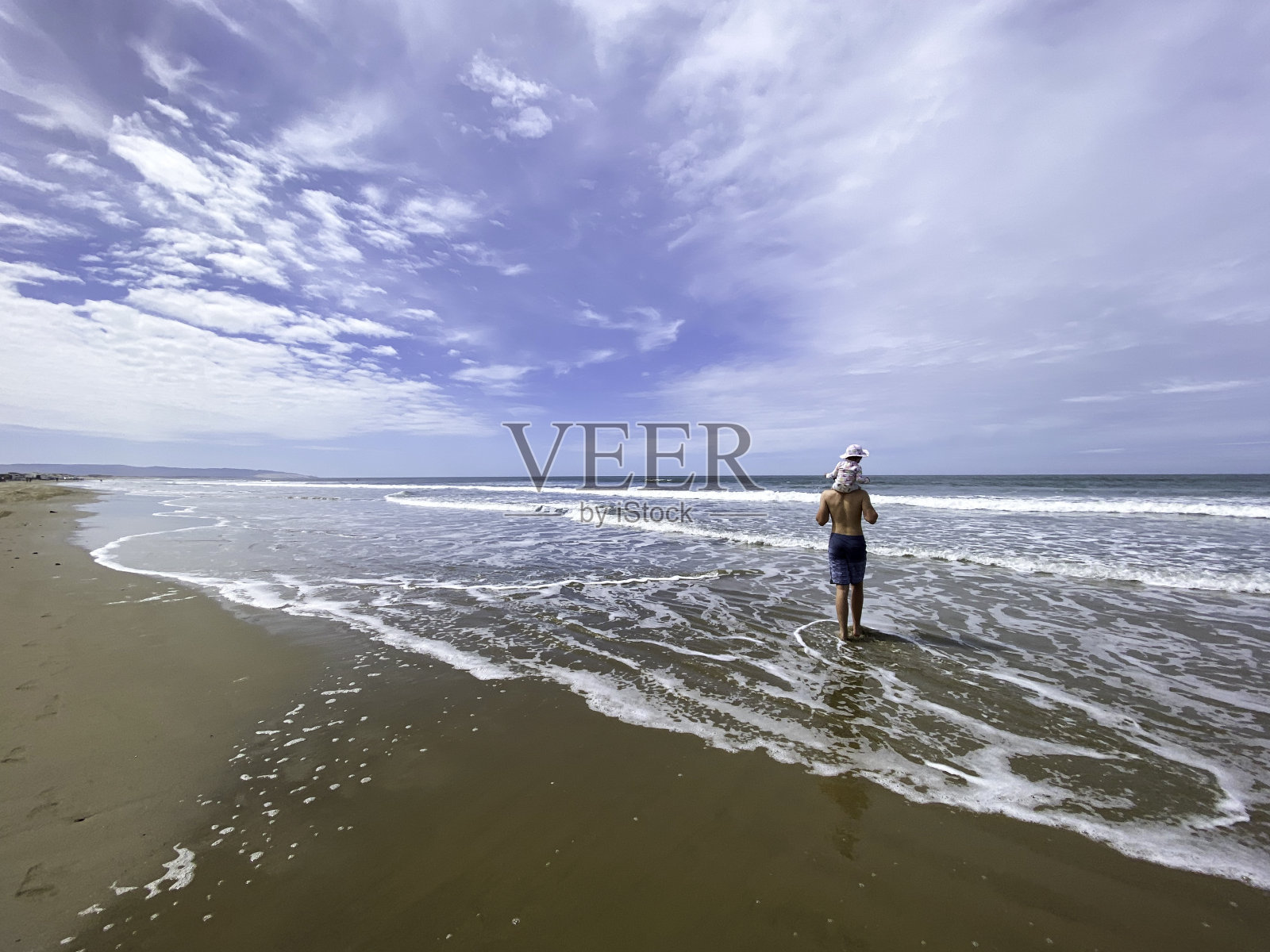 夏天，一家人带着女婴在海滩上玩耍照片摄影图片