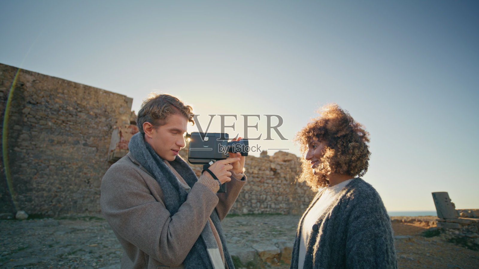 一个面带微笑的家伙拿着相机拍摄度假照片的特写。无忧无虑的新婚夫妇照片摄影图片