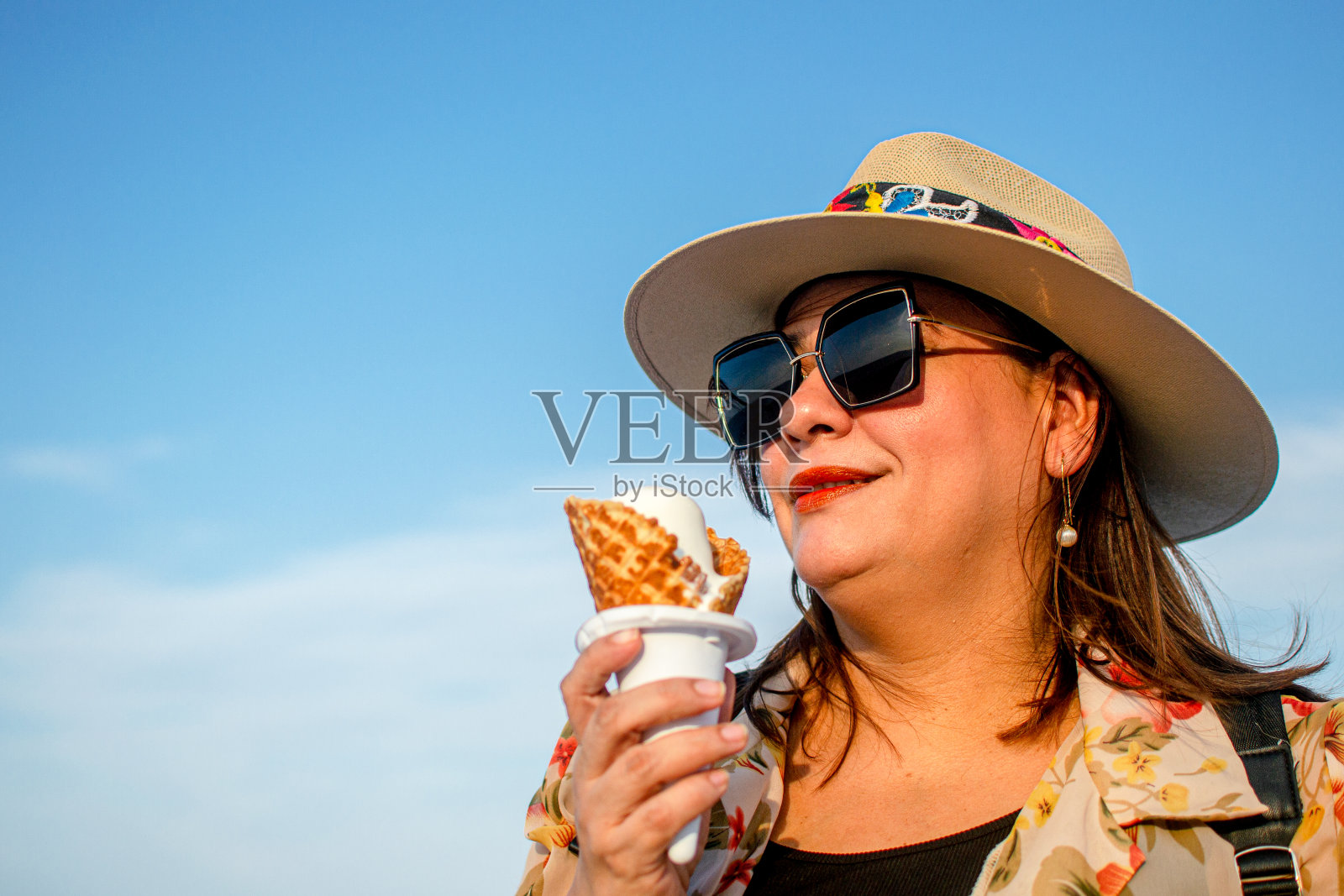 在海滩前吃冰淇淋的女人照片摄影图片