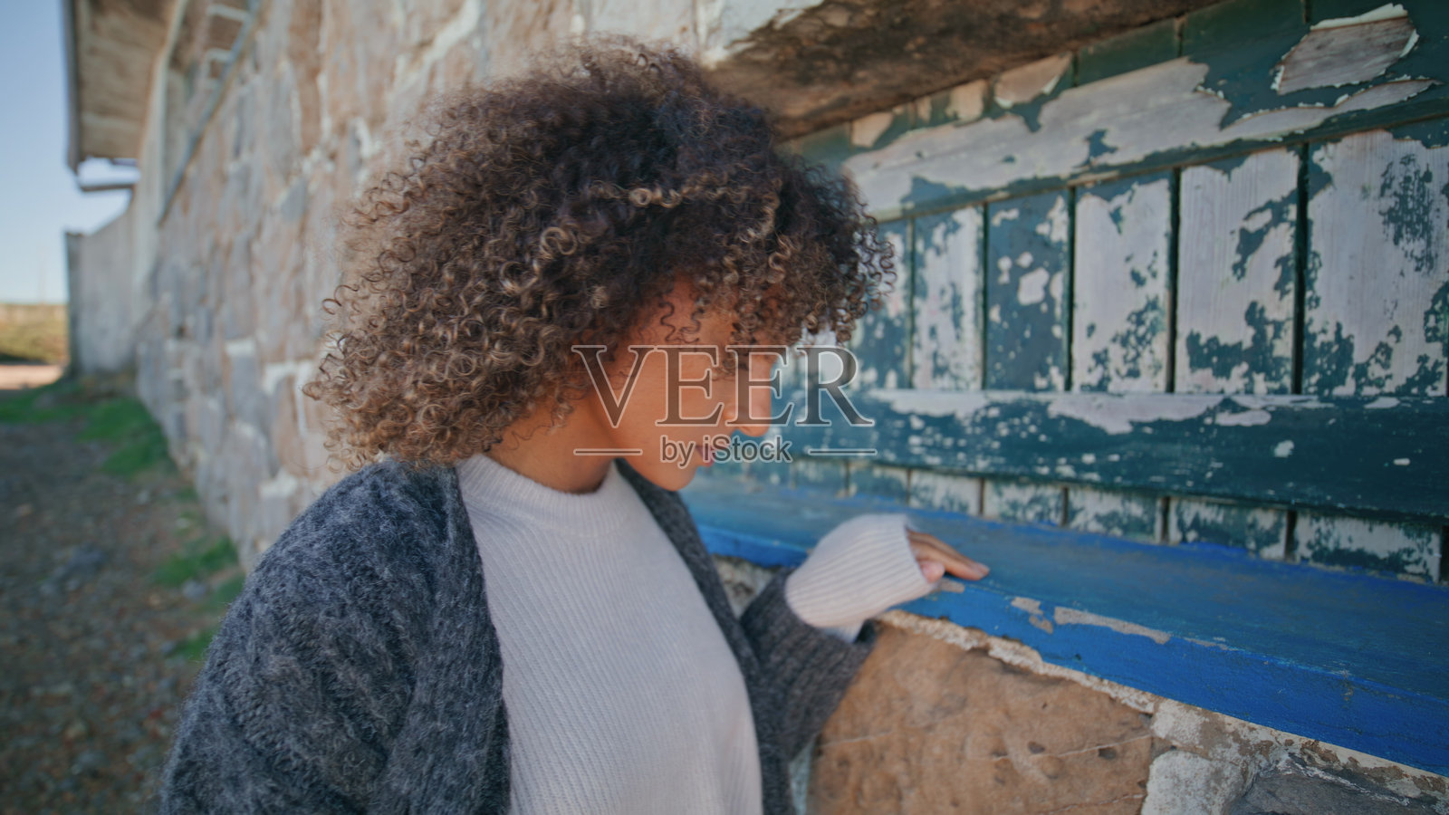 在废弃场所面露不悦、心情低落的女孩特写。压力大的模特正在思考照片摄影图片