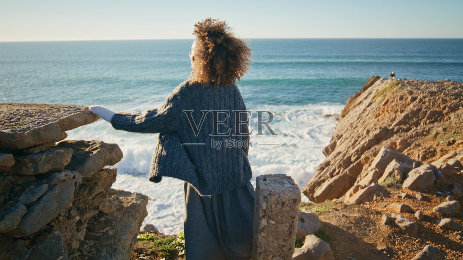 无忧无虑的黑发女郎休息海滨风景后景。女人看相机照片摄影图片
