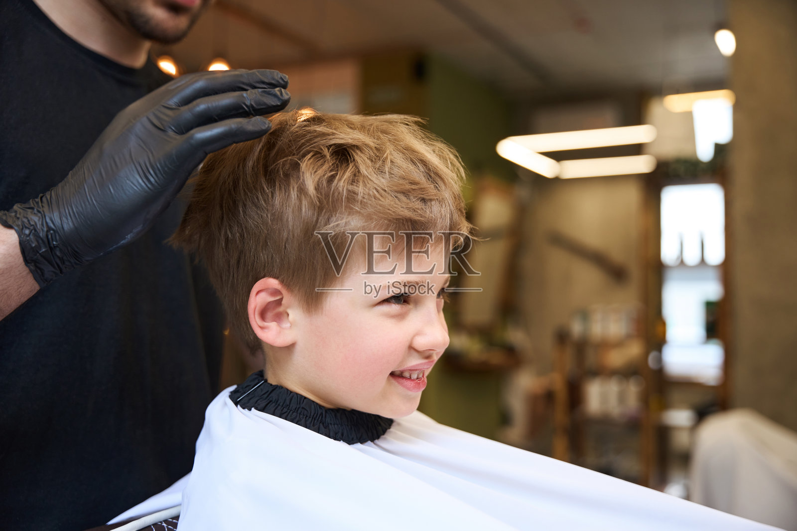 理发师正在用特殊的发胶给小男孩做发型照片摄影图片