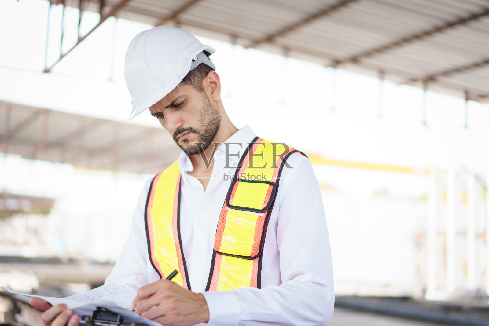 在建筑工地工作的西班牙裔男性工程师。照片摄影图片