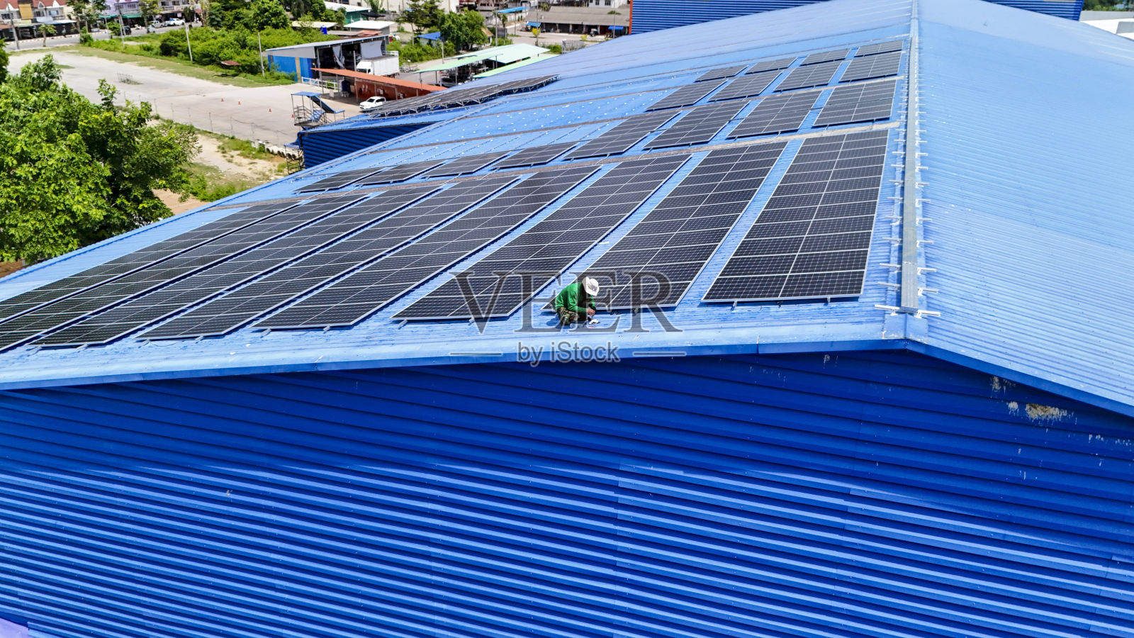 工人技术人员正在屋顶上建造太阳能电池板系统。安装太阳能光伏板系统。男技师走在屋顶结构上检查光伏太阳能组件。照片摄影图片