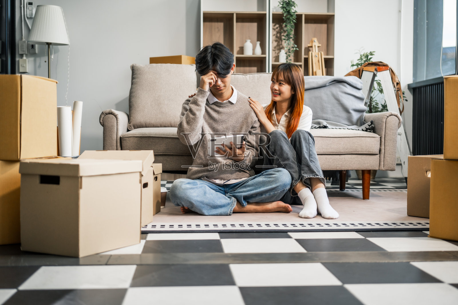 一对压力很大的年轻夫妇面临着经济挑战，在债务和账单中挣扎。尽管困难重重，他们还是互相寻求支持，手牵着手，一起面对问题。照片摄影图片