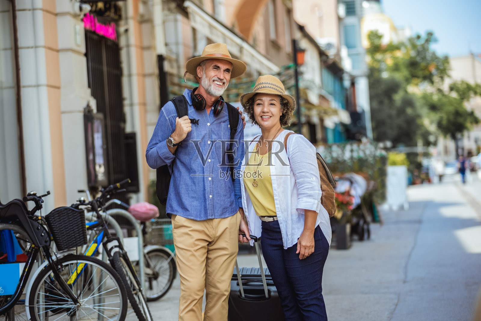一对背着双肩包走在新城里的夫妇。照片摄影图片