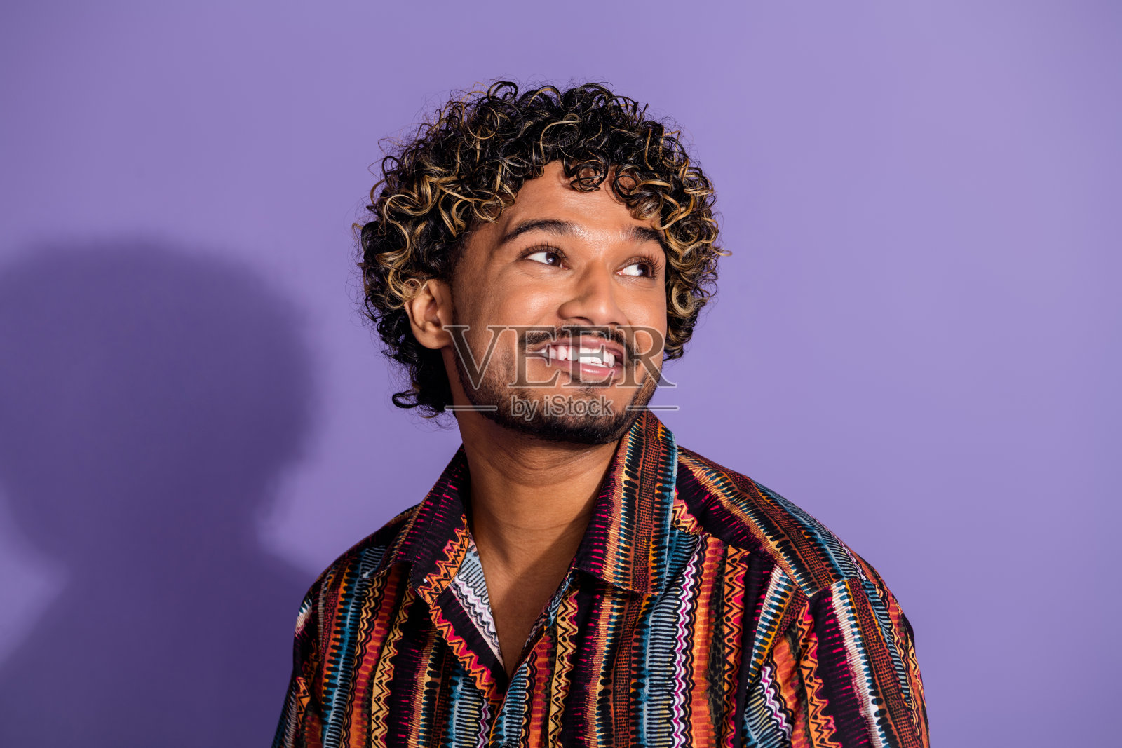 漂亮的年轻人的肖像看起来空的空间穿衬衫孤立在紫色的背景照片摄影图片