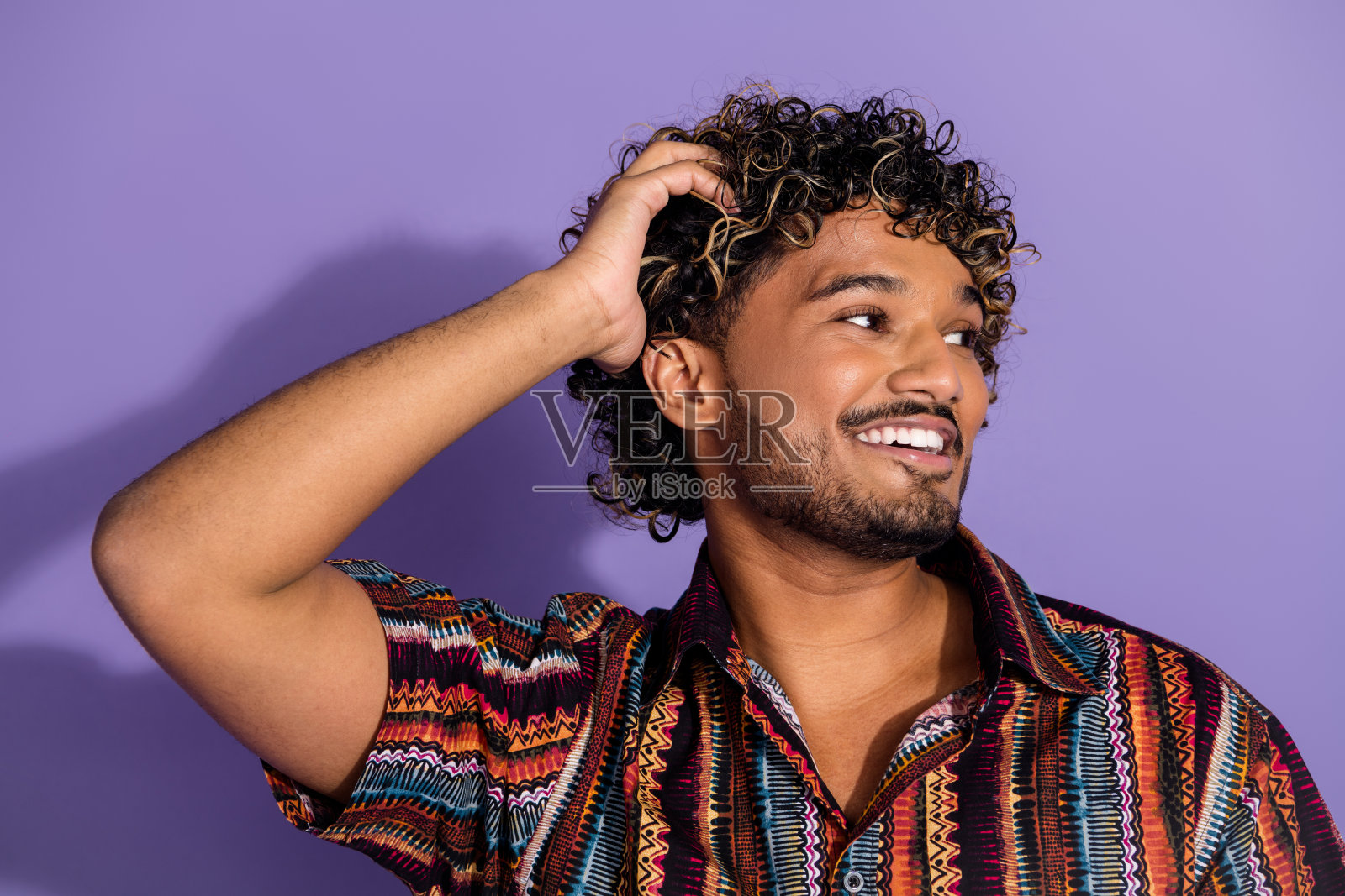 照片的愉快的男人与胡子触摸波浪发型穿着印花衬衫看标志空白空间孤立的紫色背景照片摄影图片
