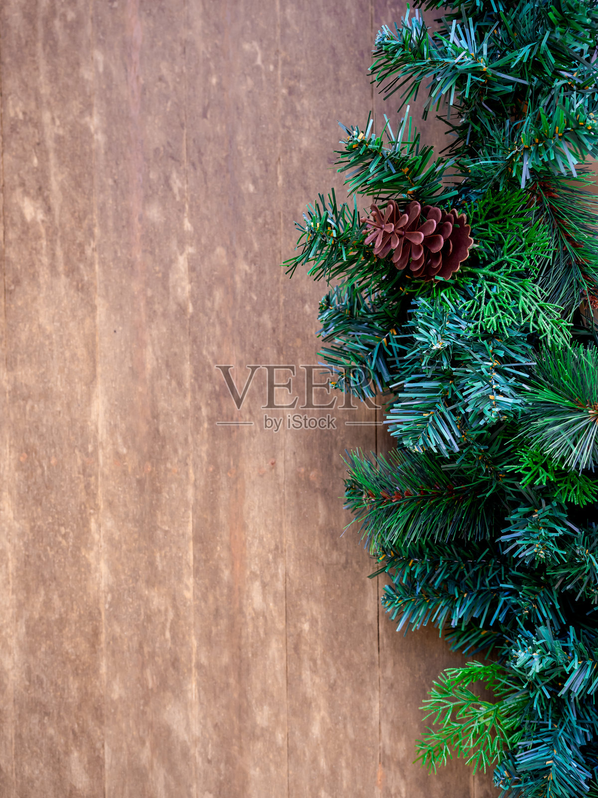 圣诞快乐，新年快乐的概念。特写绿色圣诞树，用松果装饰木制背景与复制空间，节日派对装饰，垂直风格。照片摄影图片