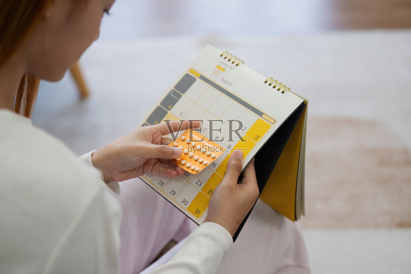 手持避孕药和日历的妇女，计划怀孕，计划生育概念照片摄影图片