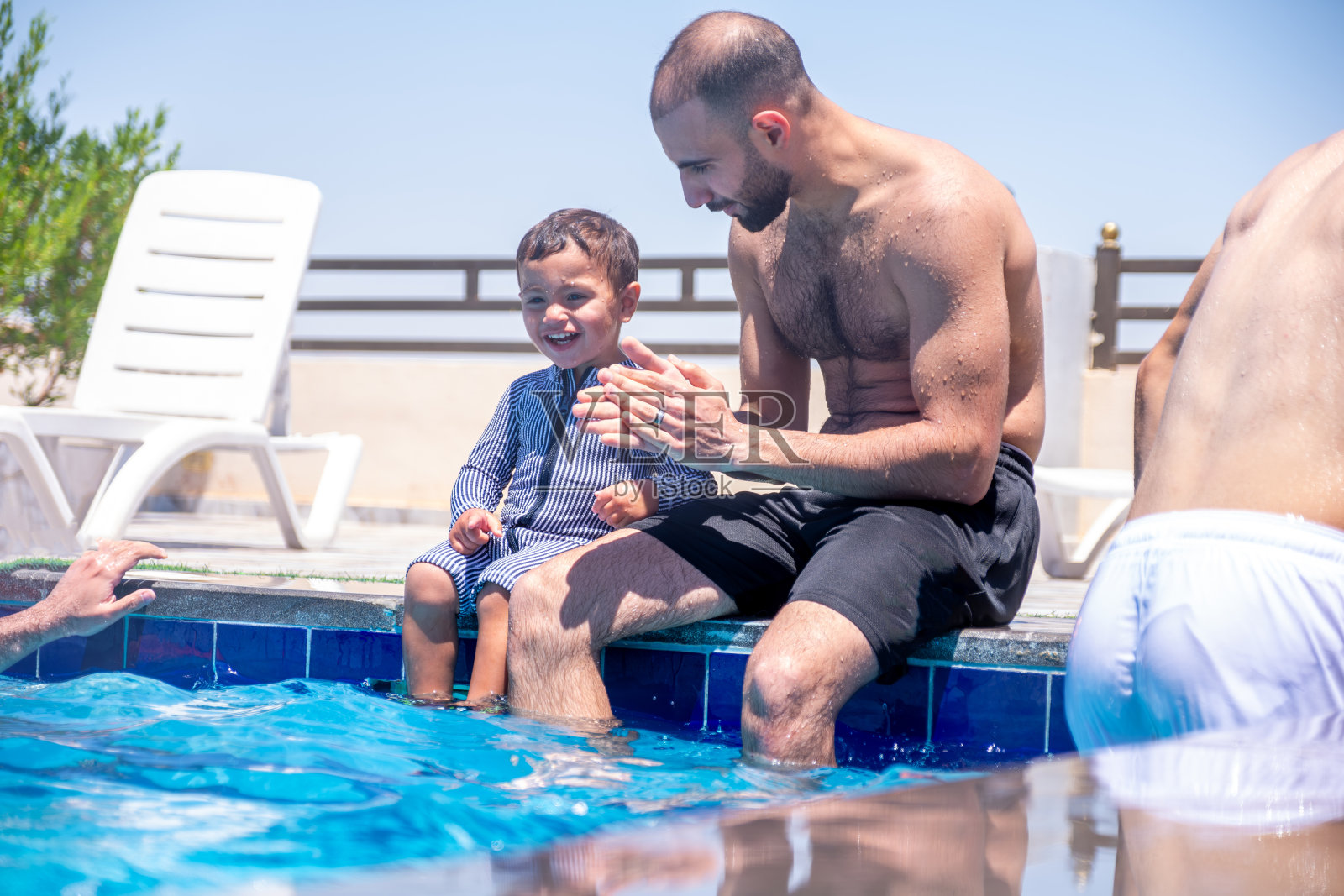 不同年龄段的亲戚在游泳池里玩耍，一起度过美好时光，互相支持，充分享受假期照片摄影图片