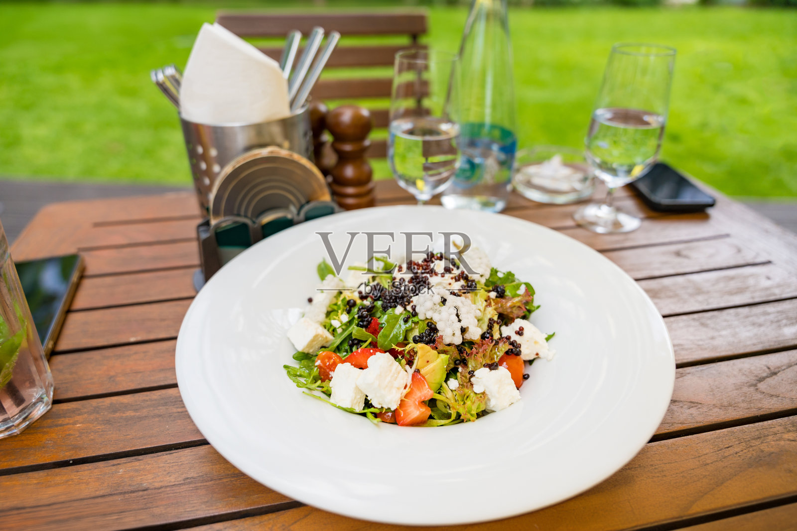 欧洲捷克餐厅的牛油果沙拉配新鲜蔬菜、芝麻菜和奶酪。照片摄影图片