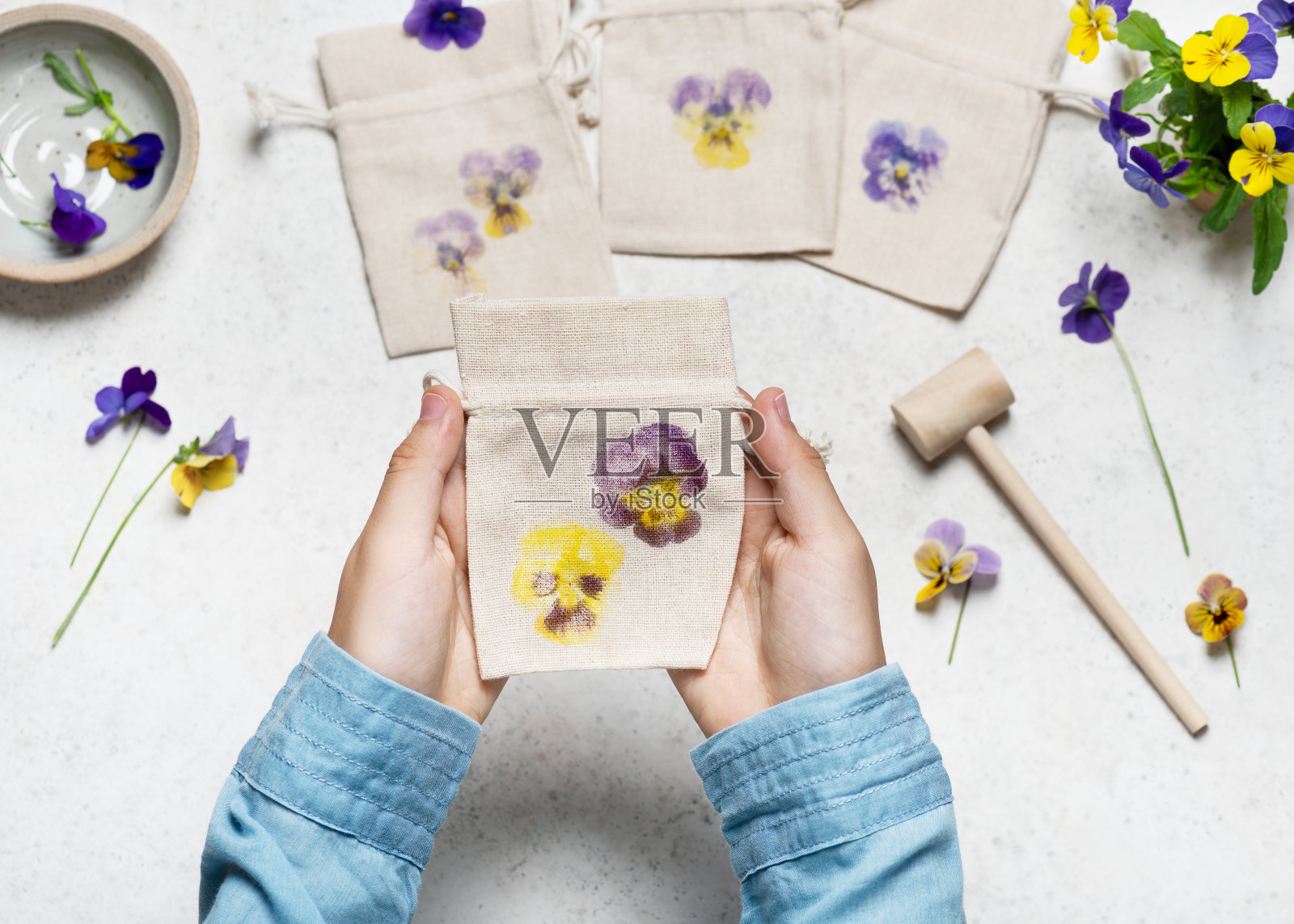 从上面的一个小手工织物袋与锤打三色堇花印花。照片摄影图片