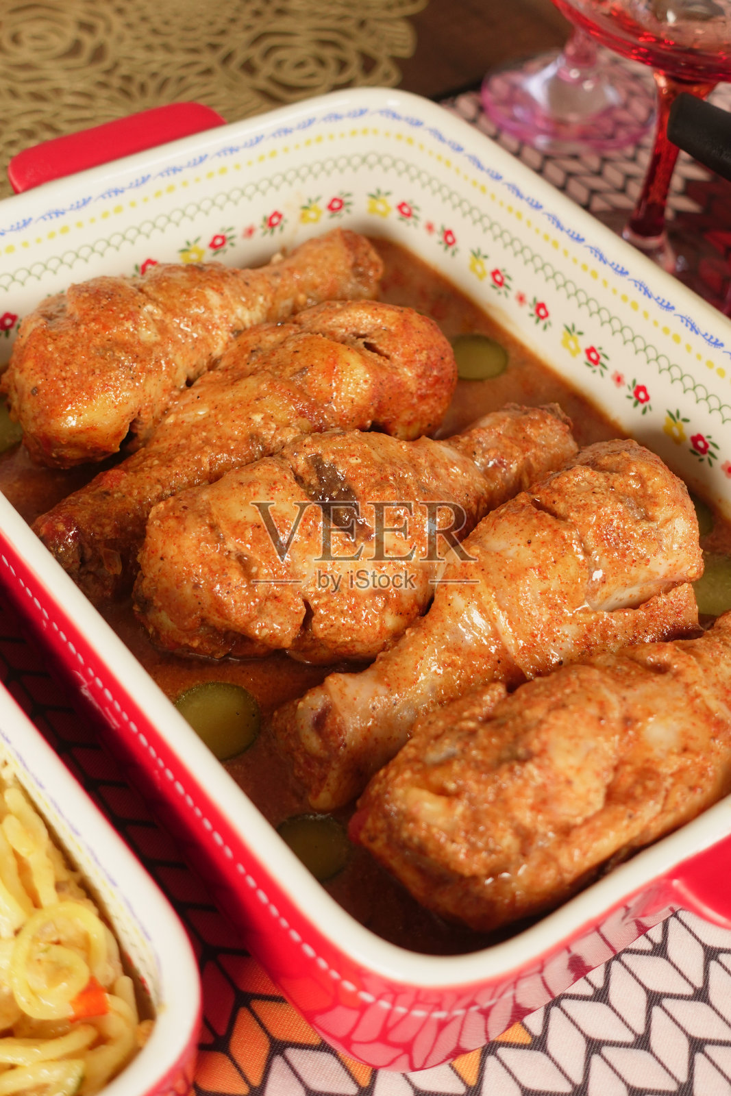 美味丰盛的烤鸡腿装在红白相间的盘子里，配上装饰照片摄影图片
