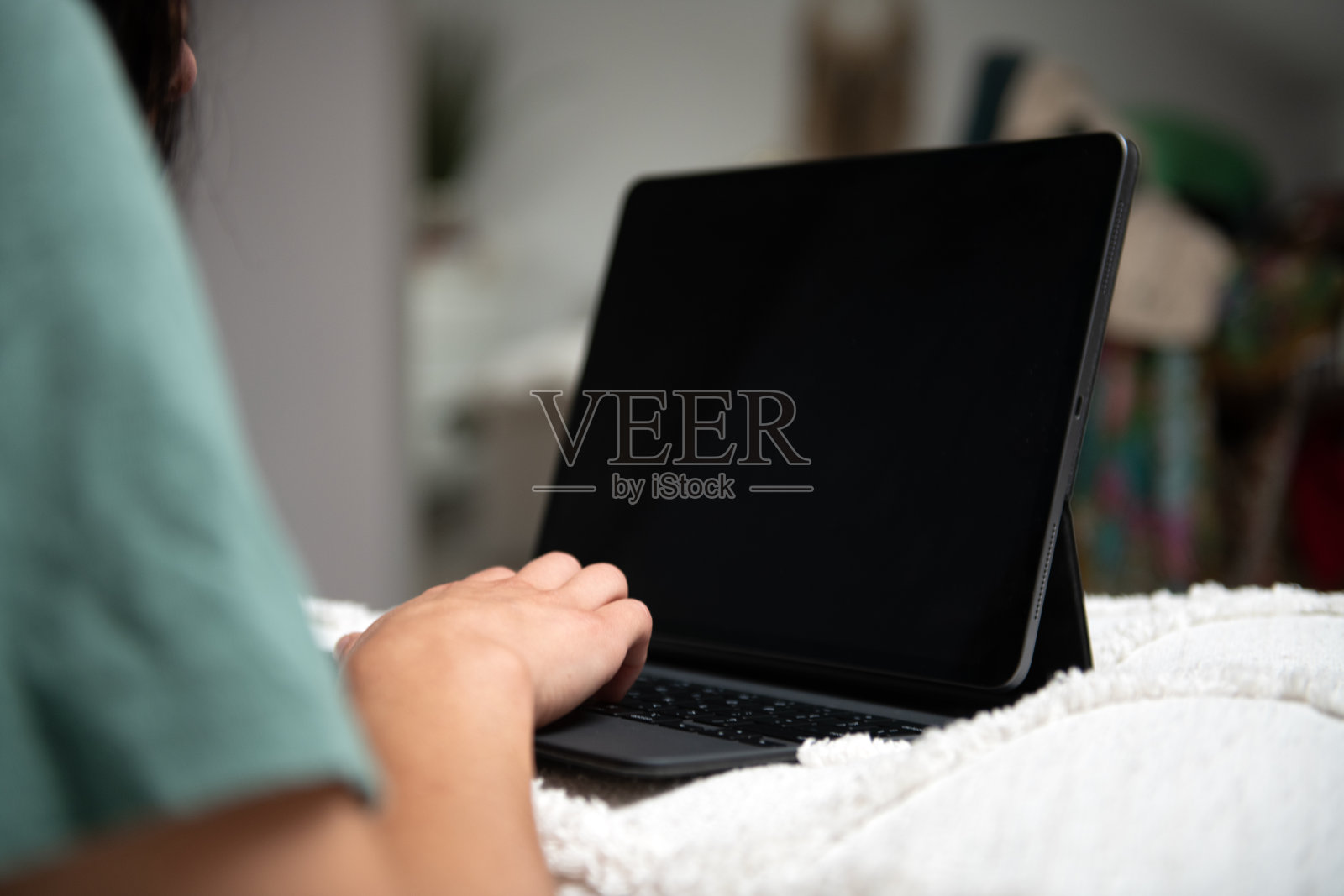 在床上用手和笔记本电脑打字，用键盘进行社交媒体研究项目照片摄影图片