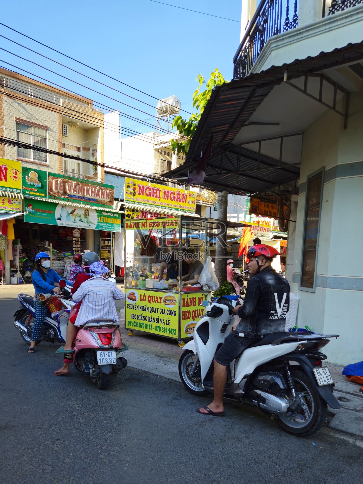 越南永隆省芒提区蔡恩镇当地市场街道的清晨街景。骑摩托车的人。照片摄影图片