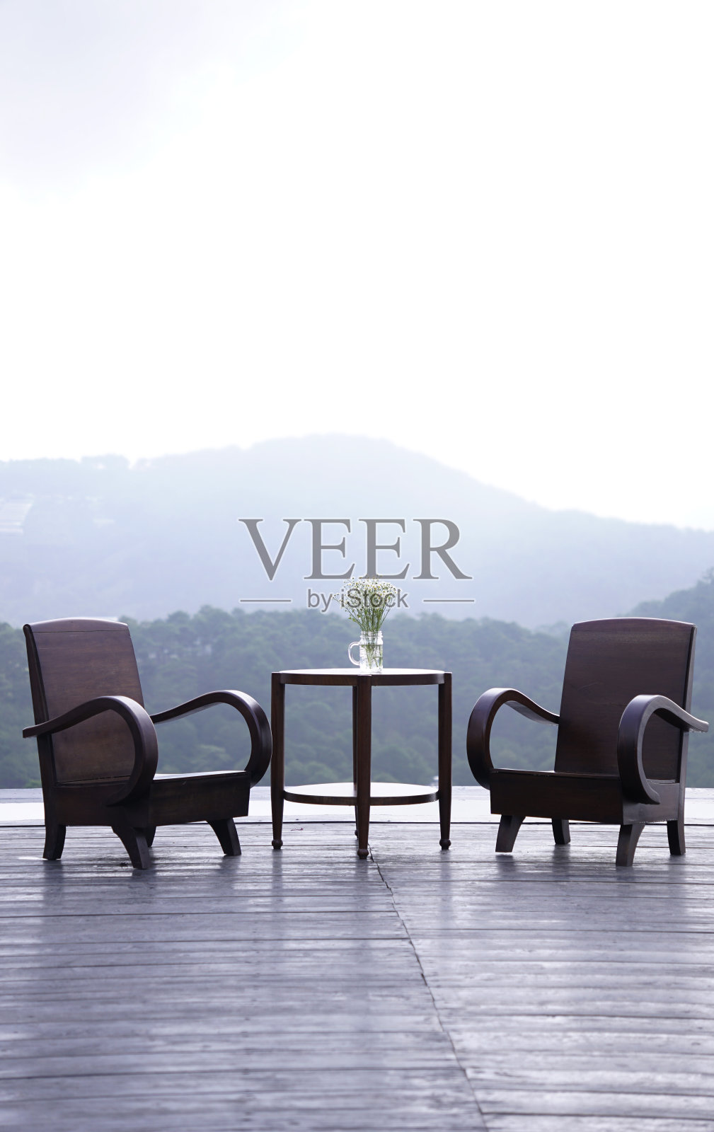 露台上的木椅和桌子，背后是天空和山的景色照片摄影图片