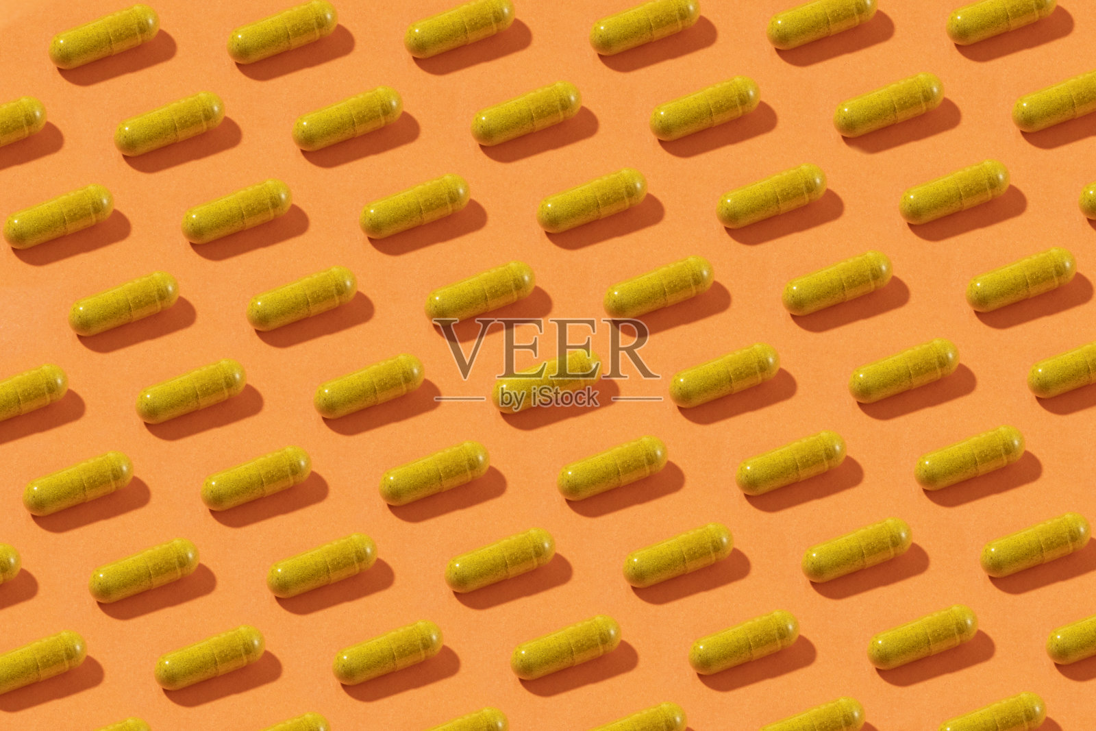 橙色背景上的黄色药丸照片摄影图片