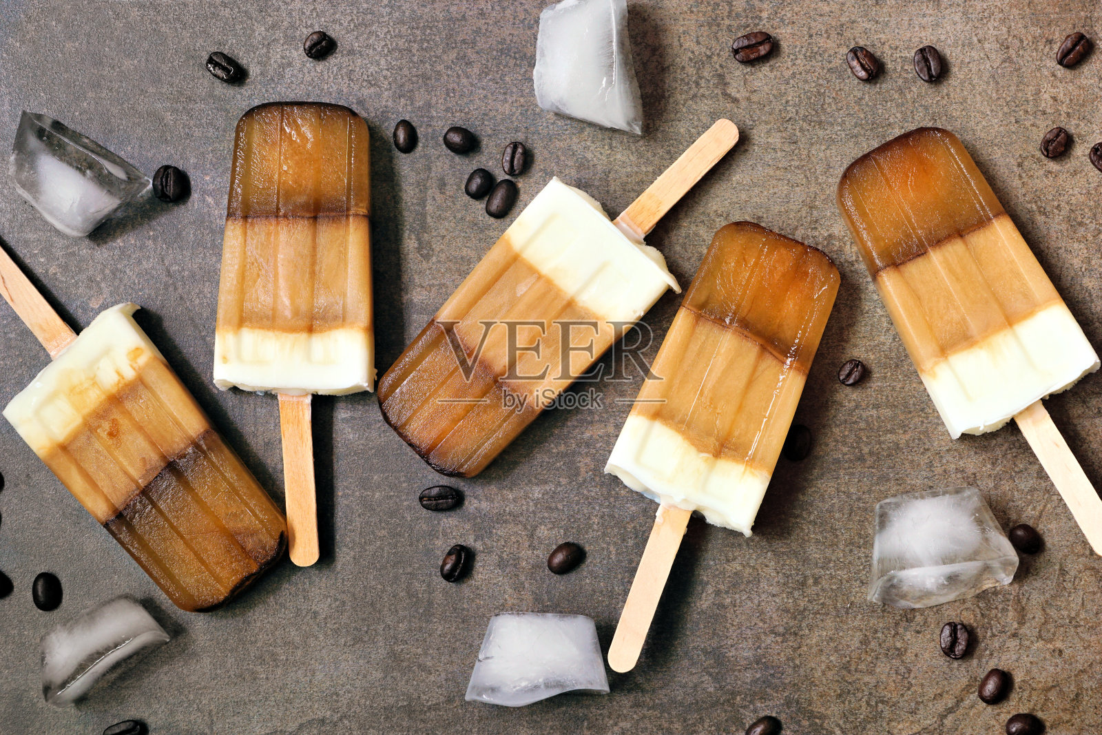 咖啡和奶油冰棒散落在棕色的背景上照片摄影图片