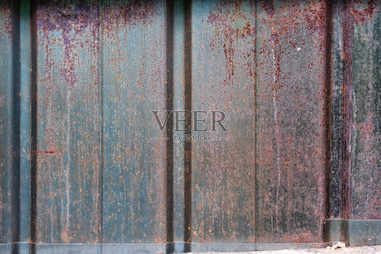 一堵由金属型材制成的旧黑墙的碎片。有凹槽。表面有锈。背景。纹理。照片摄影图片