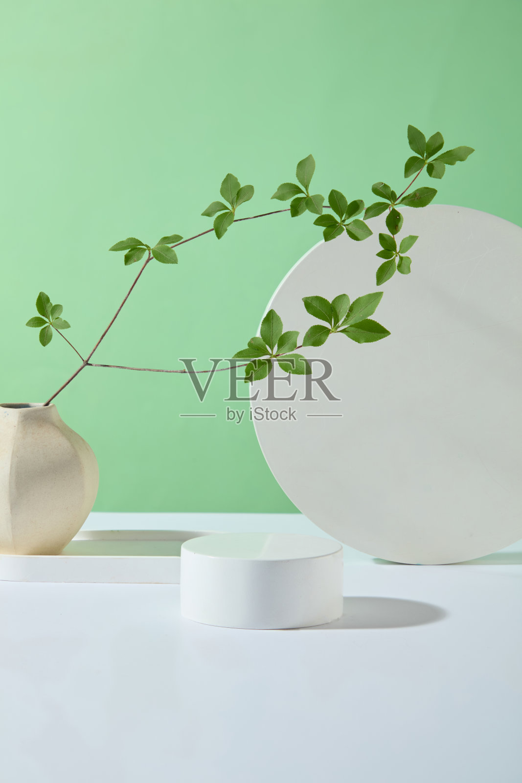 绿色背景，绿色叶子的自然概念广告照片，中间展示一个圆形的空展示台，用于展示产品，具有自然成分照片摄影图片