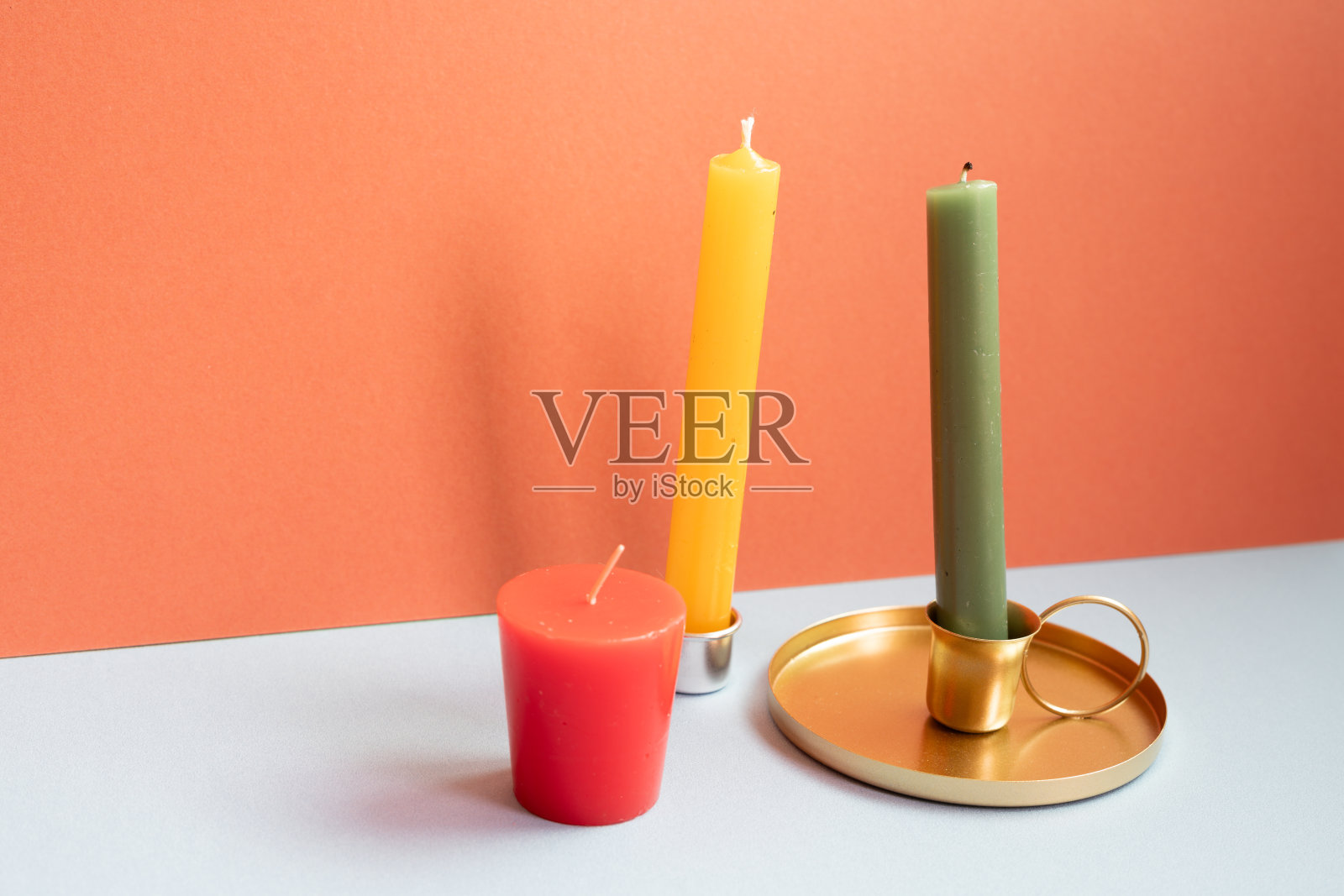灰色桌子上的蜡烛。红墙背景照片摄影图片