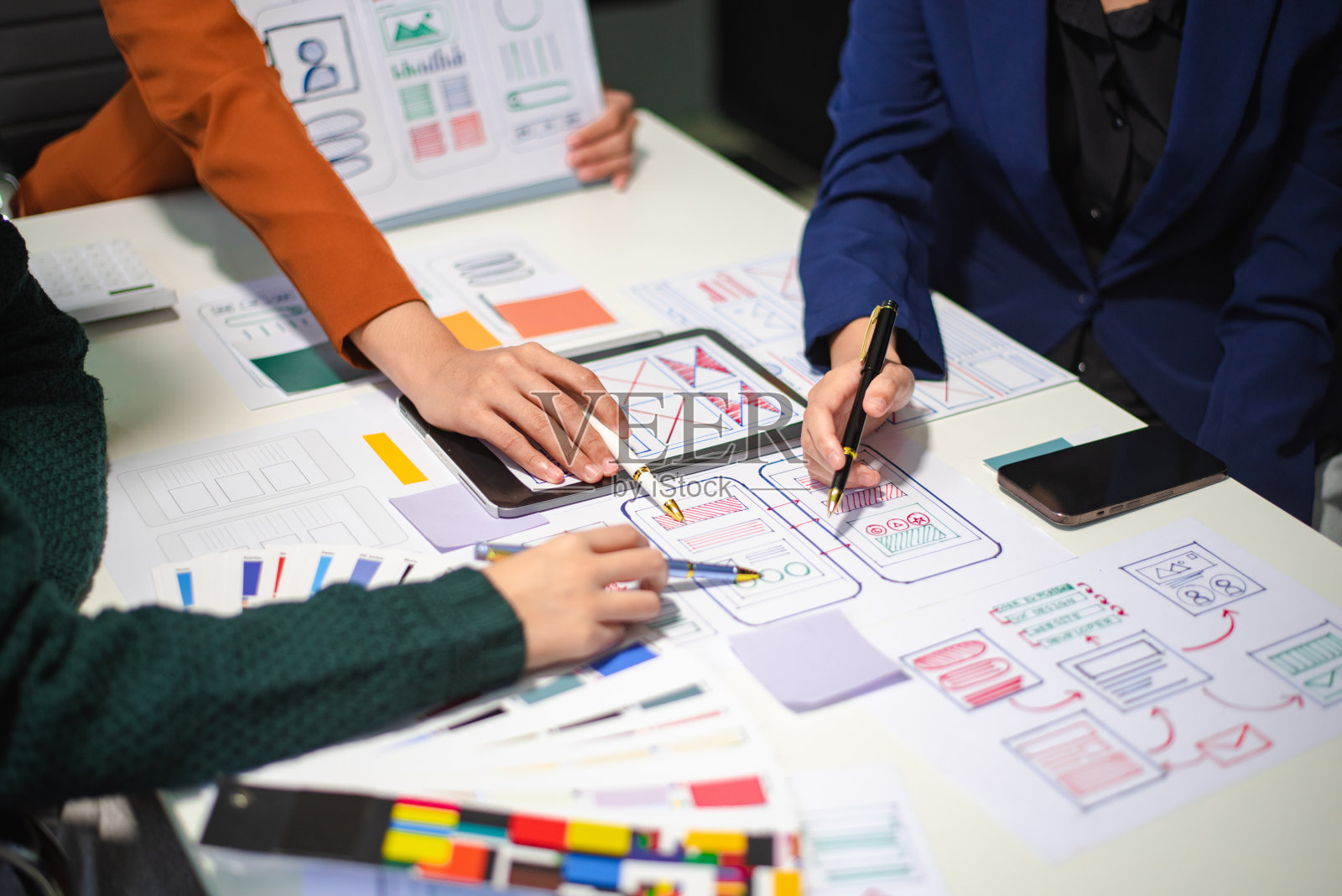 UI开发团队用笔记本电脑、智能手机和数字平板电脑进行项目头脑风暴的特写。照片摄影图片