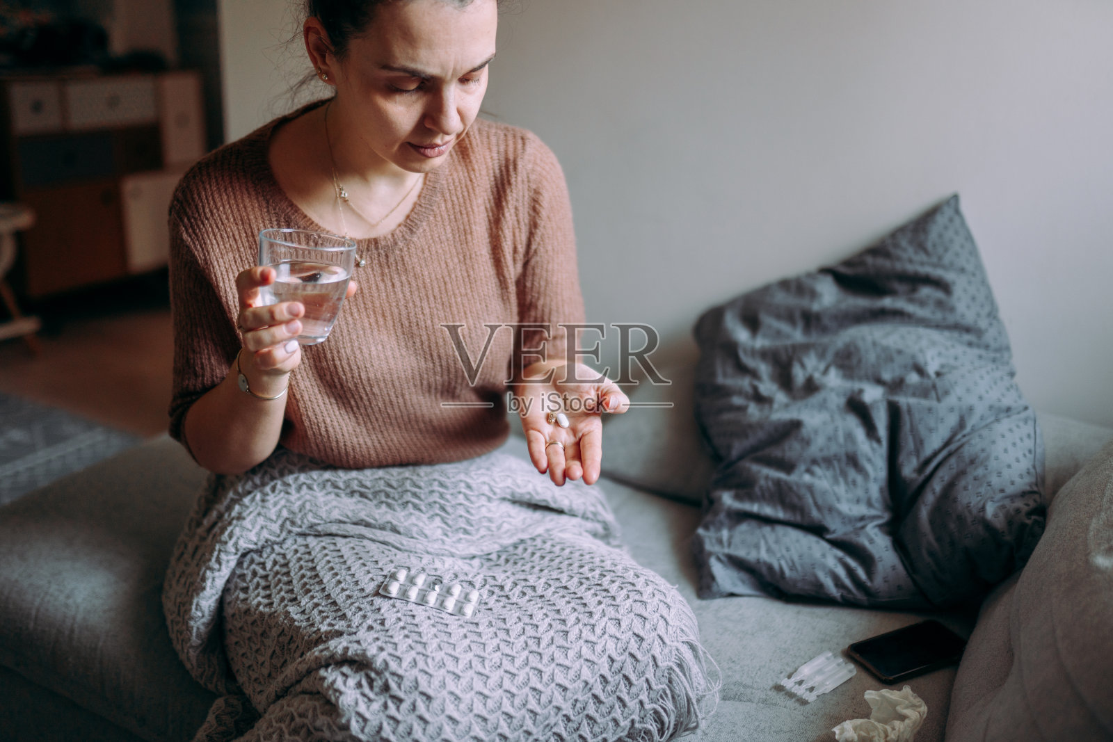 拿着水杯服药的女人照片摄影图片