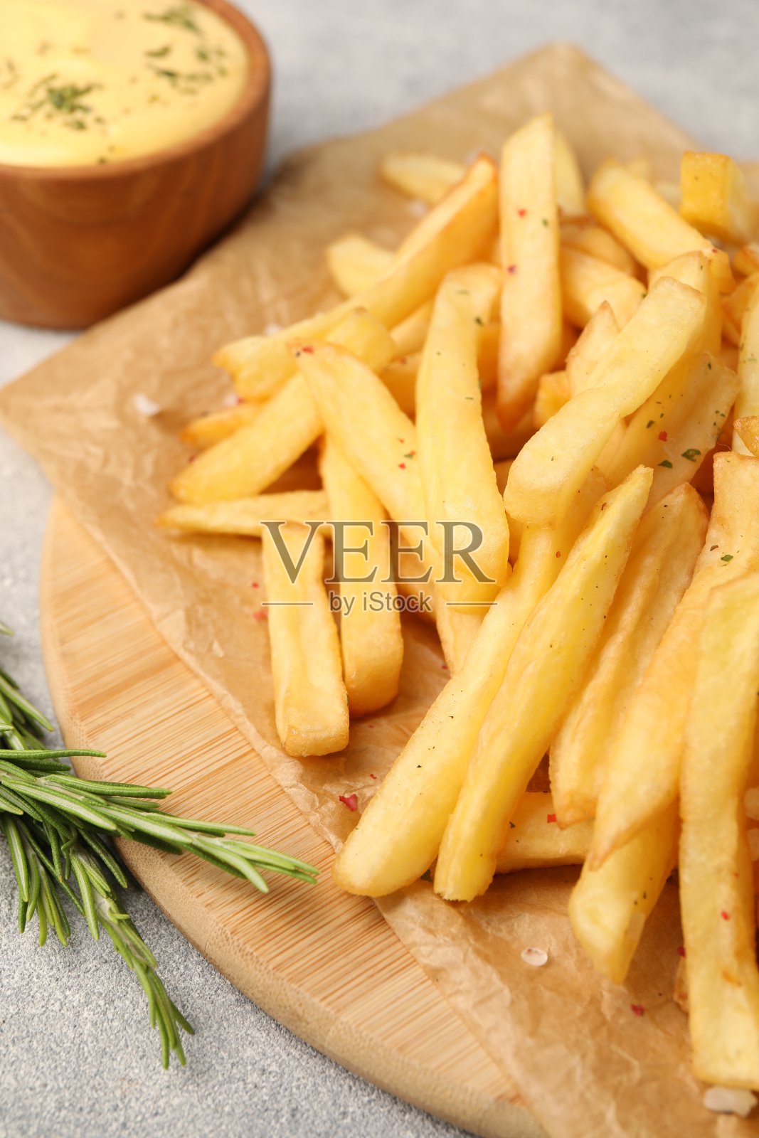 美味的薯条配上酱汁，放在灰色纹理的桌子上，特写照片摄影图片