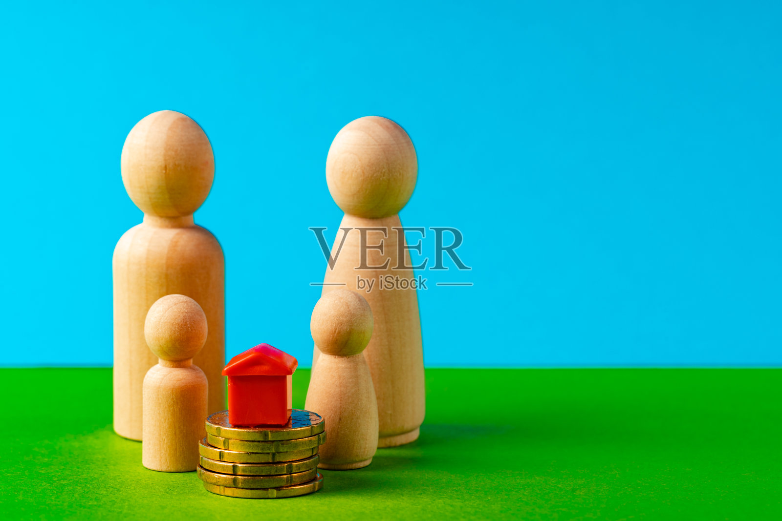 木制的家庭，玩具屋和一堆硬币。储蓄买房概念照片摄影图片