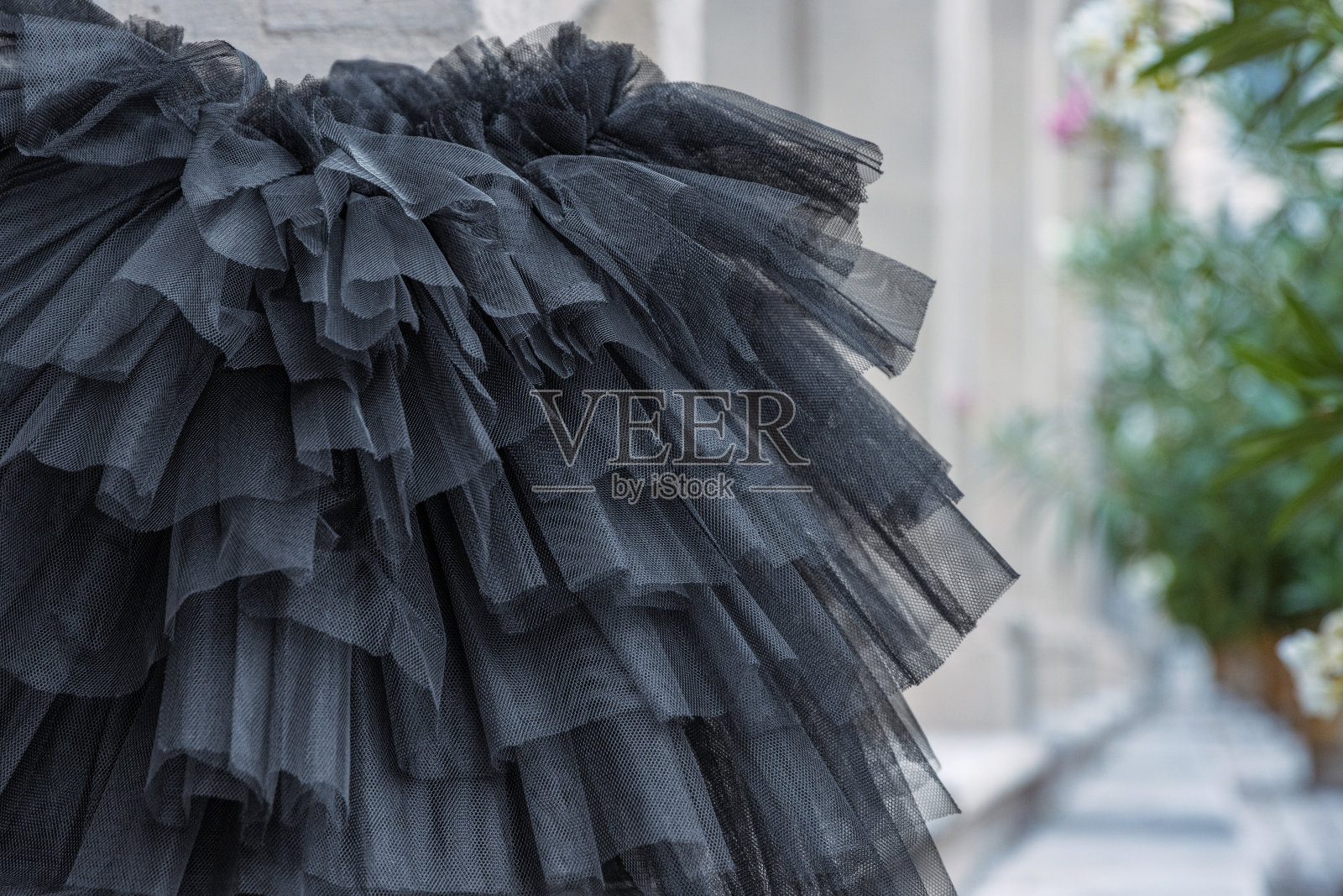 黑色层层叠叠的芭蕾舞裙铺在石阶上。薄纱芭蕾舞裙。多层黑色裙子。特写镜头。有选择性的重点照片摄影图片