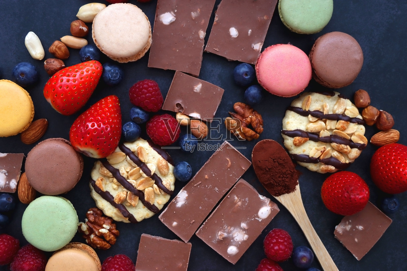 糖果，浆果和坚果在黑暗的背景照片摄影图片