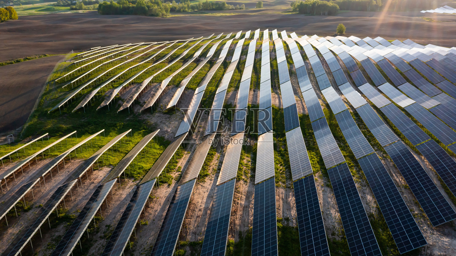 太阳能电池板上的航拍照片，阳光明媚的农村地区有绿色的土地照片摄影图片