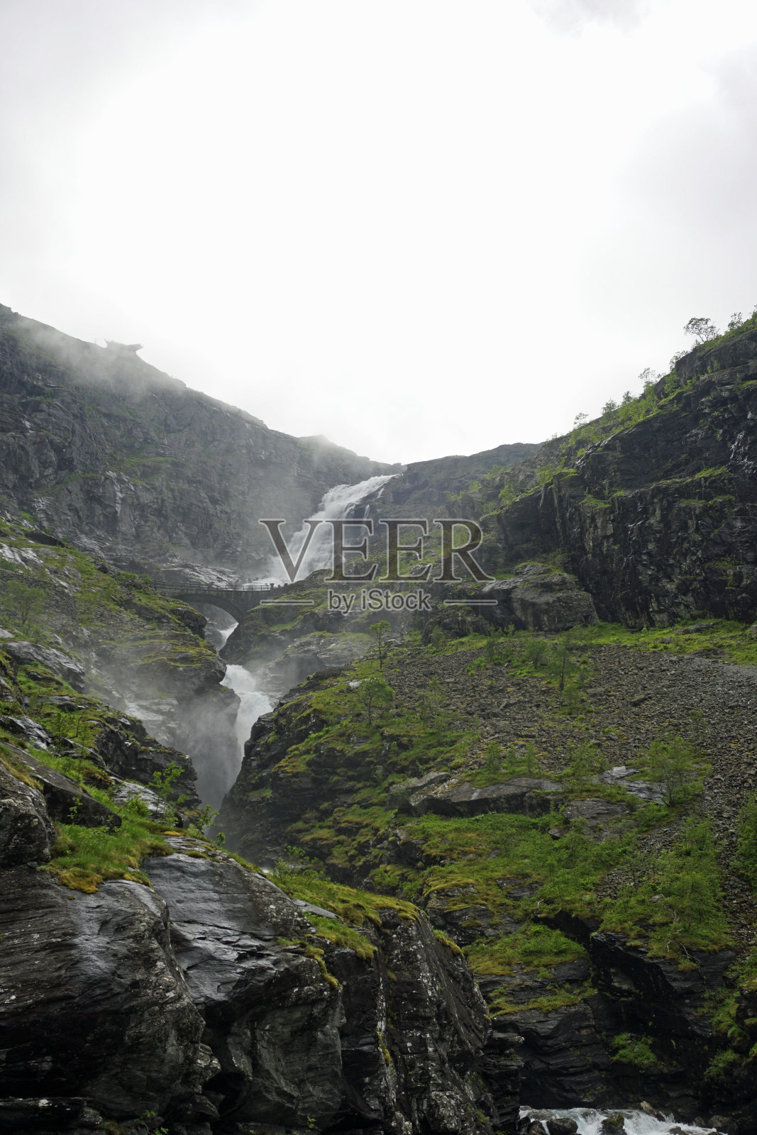 挪威的自然风光。巨魔路上的瀑布。阴天和山顶上的云。照片摄影图片