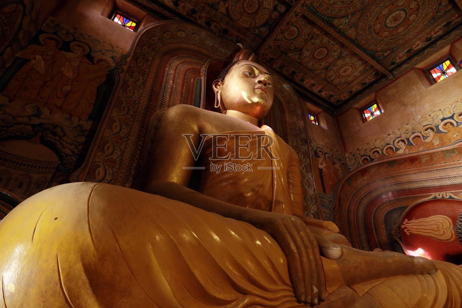 斯里兰卡佛寺内的大坐佛雕像，用绘画和壁画装饰。照片摄影图片