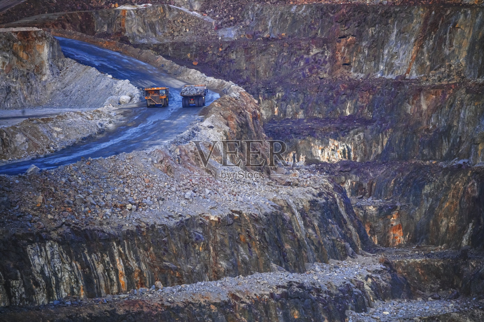 采矿卡车在露天梯田矿山蜿蜒的道路上行驶，力拓矿业。照片摄影图片